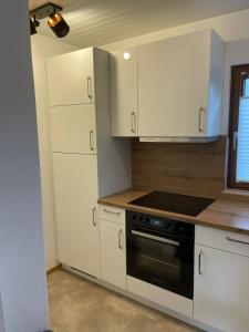 a kitchen with white cabinets and a stove at Ferienhaus Seepark Kirchheim in Kirchheim