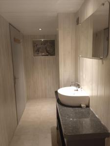 uma casa de banho com um lavatório branco e um balcão preto em Chambres d'hôtes du Péras em Saint-Jean-du-Gard