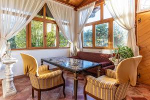 sala de estar con mesa de cristal y sillas en La Villa del Barone, en Predaia