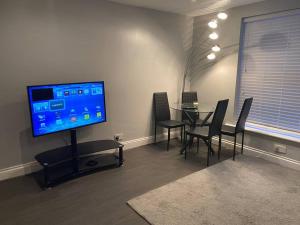 a dining room with a table and a flat screen tv at Spacious 2 bedroom flat london in London