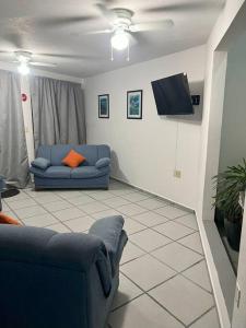 sala de estar con sofá azul y TV en CASA Punto Medio en Tlayacapan