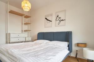 a bed with a blue headboard in a bedroom at Villa LORA - Ferienwohnung Federspiel in Mautern