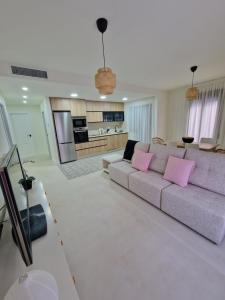 a living room with a couch and pink pillows at APARTAMENTO V27 in Baeza