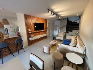 un soggiorno con divano, sedie e TV di Kanui Casa Maré 109 a São Miguel dos Milagres Altre 68 foto