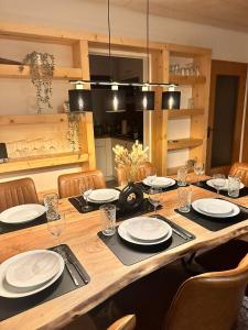 una gran mesa de madera con platos y copas de vino en Ferienhaus Seepark Kirchheim en Kirchheim