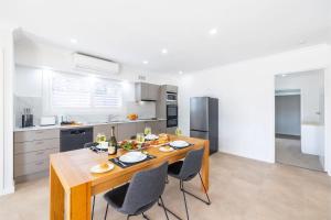 安娜湾50a Ocean Ave - air con, wi-fi 1 bedroom apartment的一间厨房,内设一张木桌和椅子