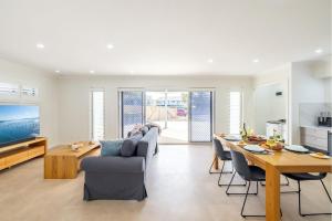 安娜湾50a Ocean Ave - air con, wi-fi 1 bedroom apartment的配有桌椅的厨房和客厅
