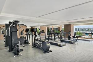 a gym with treadmills and exercise equipment in a building at The Artiste Kochi, a Tribute Portfolio Hotel in Cochin