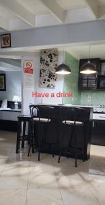 a kitchen with two chairs and a bar with a have a drink sign at Mystic Ridge Paradise in Ocho Rios