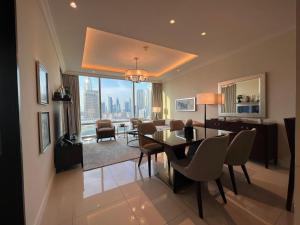 comedor y sala de estar con mesa y sillas en Downtown Dubai Address Fountain Views Residences - luxurious One Bedroom Apartment, en Dubái