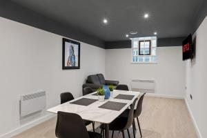 a dining room with a white table and chairs at Albion Street Studios in Derby