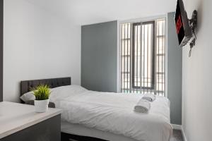 a bedroom with a white bed and a window at Albion Street Studios in Derby