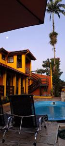 a couple of chairs sitting next to a swimming pool at Pousada Trilha da Serra in Morretes