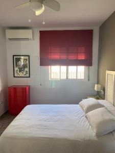 ein Schlafzimmer mit einem großen weißen Bett und einem Fenster in der Unterkunft Ático con vistas cerca del mar - Penthouse - parking - terraza in Torre del Mar + 38 Fotos