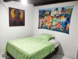 a bedroom with a bed and a painting on the wall at Casa Prudente in Olinda