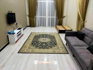 a living room with a couch and a rug at Sya Al-Yahya Homestay in Kuala Terengganu