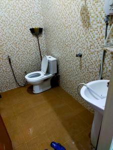 a bathroom with a toilet and a sink at Sya Al-Yahya Homestay in Kuala Terengganu