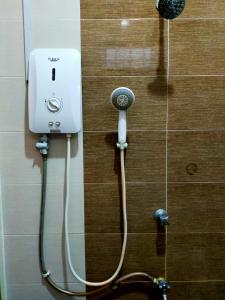 a bathroom stall with a shower with a hose at Sya Al-Yahya Homestay in Kuala Terengganu