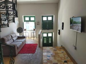 a living room with a couch and two green doors at Casa Prudente in Olinda