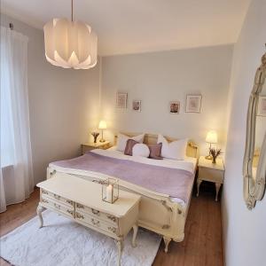 a white bedroom with a large bed and a chandelier at Unsere neue Ferienwohnung Hereinspaziert 