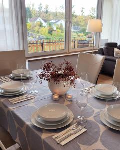una mesa de comedor con platos y copas de vino en Unsere neue Ferienwohnung Hereinspaziert 