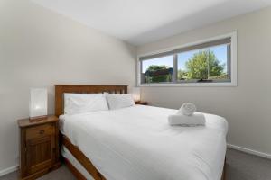 a bedroom with a large bed and a window at T Bar on Twynam in Jindabyne