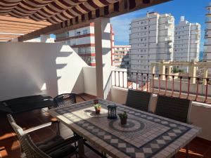 ein Tisch auf einem Balkon mit Blick auf die Stadt in der Unterkunft Ático con vistas cerca del mar - Penthouse - parking - terraza in Torre del Mar