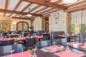 un restaurante con mesas y sillas con servilletas rojas en Hotel Le Bourgogne, en Cuiseaux