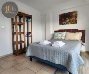 1 dormitorio con 1 cama con toallas en Josefina 4D en Ushuaia