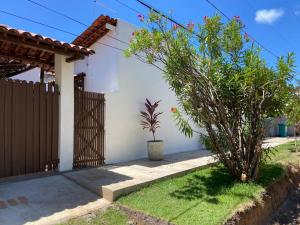 una casa blanca con una valla y una planta en Casa Paraiso de Sonho Verde, en Paripueira