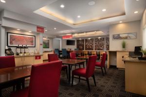 ヒューストンにあるTownePlace Suites by Marriott Houston Westchaseのダイニングルーム(テーブル、赤い椅子付)