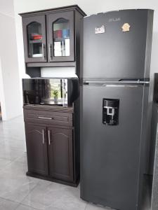 a kitchen with a stainless steel refrigerator and a cabinet at Arenal Vistas del Paraiso in Nuevo Arenal