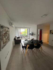 a living room with a dining room table and chairs at Departamento nuevo con seguridad y pileta ,en villa allende a 15 del centro de Córdoba in Villa Allende