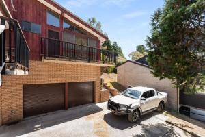 a white truck parked in front of a house at Eliza Lee 3 - 3BR Apartment l Air-Con l WiFi l Double Garage in Jindabyne