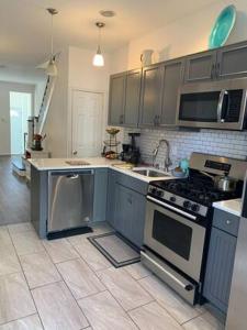 a kitchen with a stove and a sink at Point Breeze South Philly (2 bedrooms) in Philadelphia