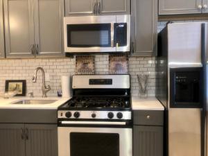 a kitchen with a stove and a microwave at Point Breeze South Philly (2 bedrooms) in Philadelphia