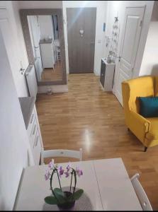 een woonkamer met een tafel en een gele bank bij Logement à côté de l'aéroport Orly in Athis-Mons