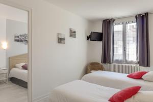 Habitación de hotel con 2 camas y espejo en Hotel Le Bourgogne, en Cuiseaux