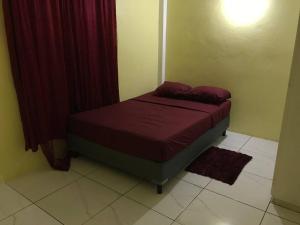 1 cama pequeña en un dormitorio con cortinas rojas en Dangleben’s Apartment, en Pointe Michel