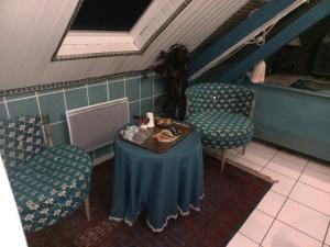 a table and two chairs in a room with a table and chairs at Location meublé de tourisme La Rose des Fables in Château-Thierry +25 photos