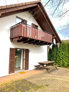 a building with a balcony and a picnic table at Ferienhaus Seepark Kirchheim in Kirchheim