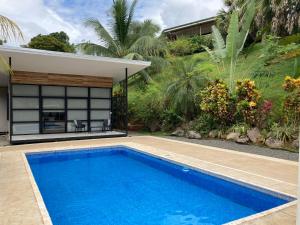 a swimming pool in front of a house at Rancho Capulin B&B in Tarcoles