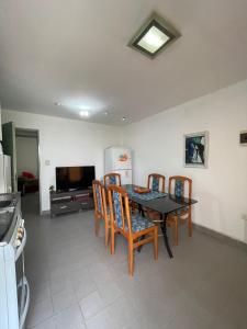 a dining room with a table and chairs and a television at La casita de sol in Puerto Madryn +10 photos