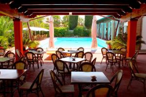 a restaurant with tables and chairs and a swimming pool at Villa Francesca Pomezia Roma in Pomezia