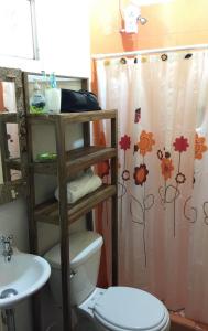 a bathroom with a toilet and a shower curtain at The Grand Mango in El Gigante