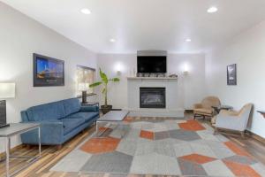 a living room with a blue couch and a fireplace at Comfort Inn & Suites Davenport - Quad Cities in Davenport