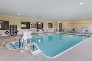 a large swimming pool with a chair in the middle at Comfort Inn & Suites Davenport - Quad Cities in Davenport