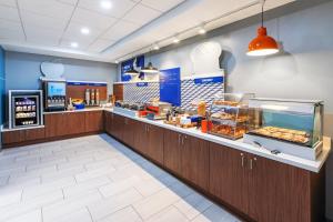 a fast food restaurant with a counter with pastries at Holiday Inn Express El Paso-Central by IHG in El Paso