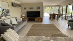 un soggiorno con divano e TV di No. 10 Coffin Bay a Coffin Bay