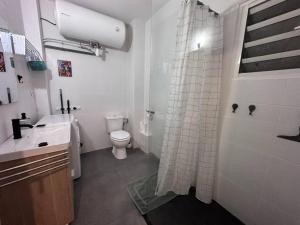 a bathroom with a toilet and a shower curtain at Studio Bellepierre in Saint-Denis